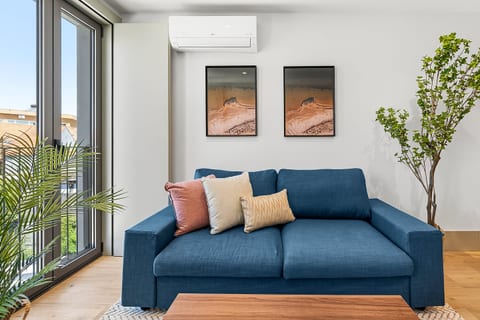 Bright modern lounge with large windows, AC, and stylish cozy seating