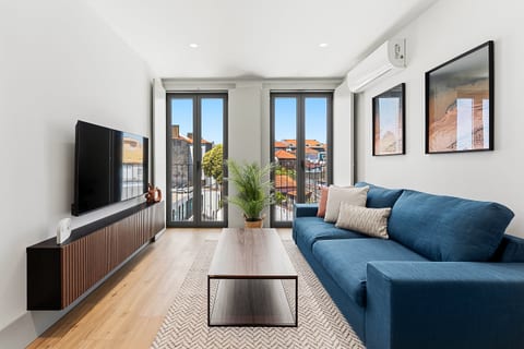 Bright modern lounge with balcony views and cozy blue sofa