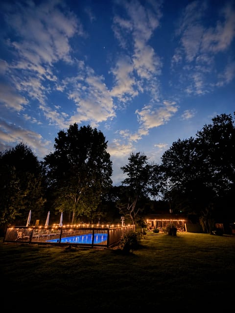 Magical twilight pool oasis with string lights and a spacious backyard
