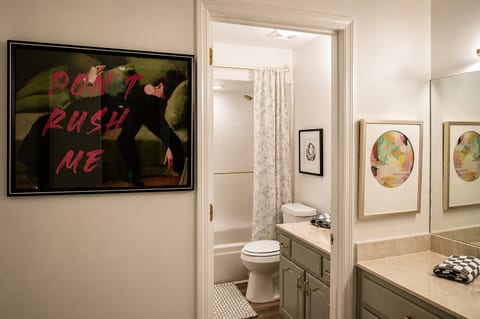 Stylish dual bathroom setup with elegant vanity and bold art accents