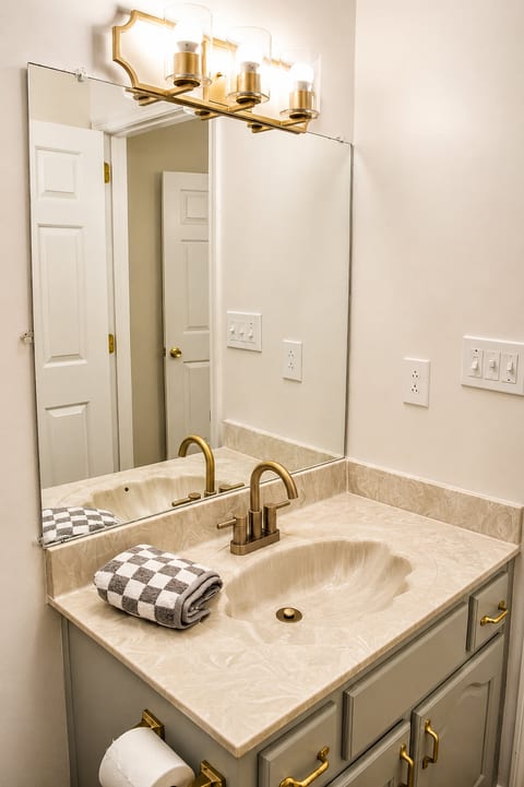 Bright updated bathroom with elegant brass finishes and spacious vanity