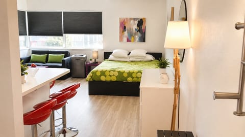 Bright modern studio with cozy bed, breakfast bar, and sunny lounge nook
