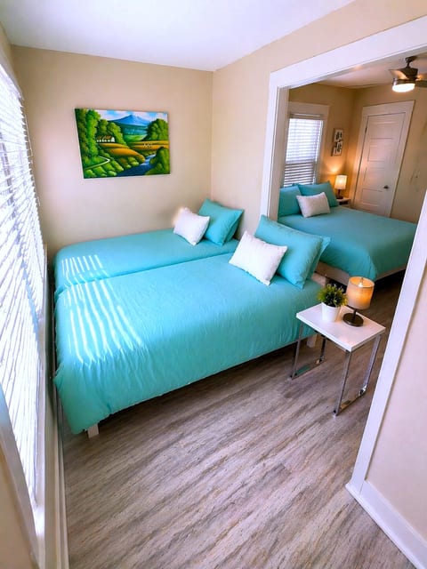 Sunny twin room with adjoining queen bed, fresh decor and light floors.