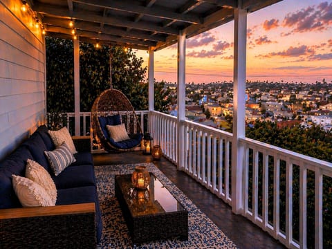 String-lit veranda with egg chair and sweeping sunset city views