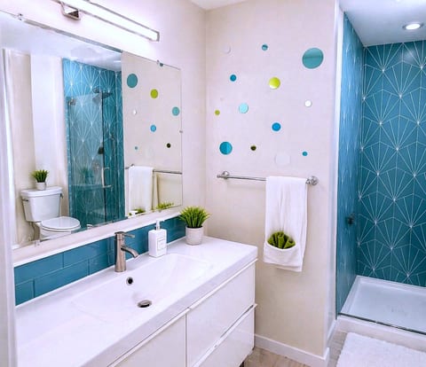 Bright, modern bath with walk-in shower and chic blue geometric tile