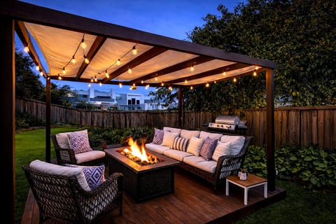 Cozy pergola lounge with fire pit, string lights & BBQ grill