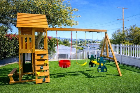 Fenced yard with playset, swings & turf—kid-approved fun!