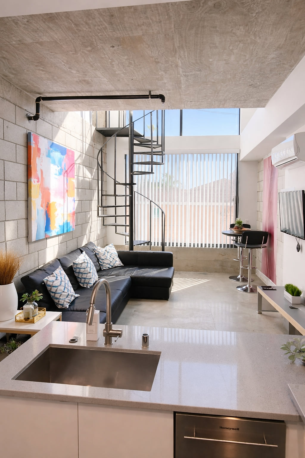Sunny loft with spiral stairs, sleek kitchen, and soaring windows