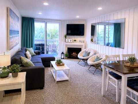 Coastal-chic lounge with fireplace, TV, and balcony retreat