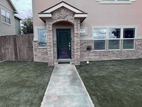 Step up to Sunset Retreat — a freshly landscaped front yard with new turf and a tidy walkway leading right to your door.