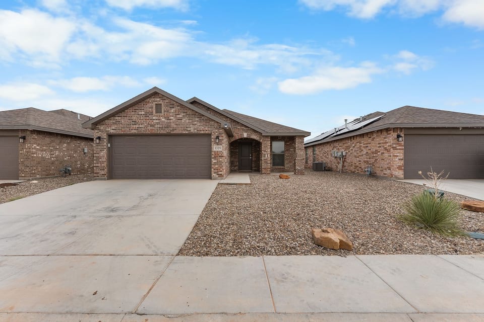Modern single-story brick home with a 2-car garage and extended driveway — easy parking and great curb appeal in a quiet Odessa neighborhood.
