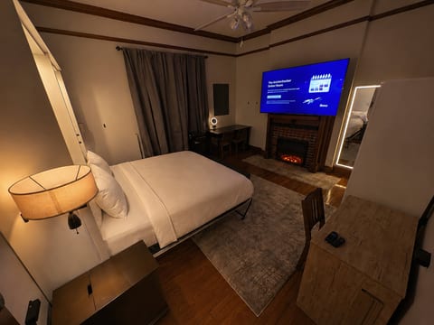 Ember Room looking in at 75" TV, frontlit mirror, fireplace.