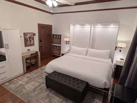 Ember room from opposite corner, bed lighting, art, armoire.