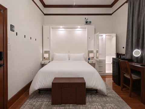 Watersong Room Queen bed with lights on, armoire, 4k projector, desk.