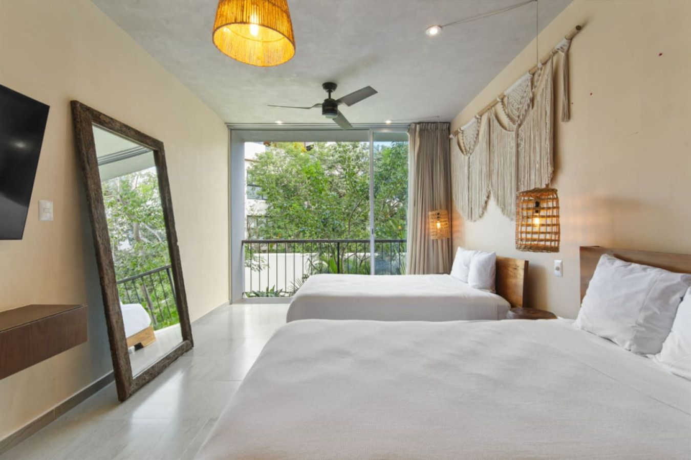 Bright and stylish! Stream your favorite shows on the wall-mounted TV or unwind on cozy beds surrounded by natural light, rattan accents, and tropical balcony views.