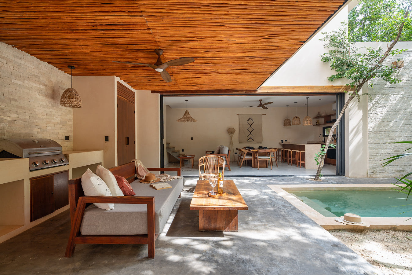 A serene indoor-outdoor retreat featuring a private plunge pool, shaded lounge, modern kitchen and natural textures. Designed for relaxed luxury, seamless living, and unforgettable stays in a tropical setting.