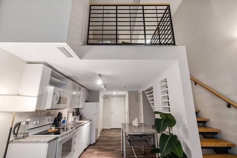 Bright modern loft with full kitchen, soaring ceilings, and stylish stairs