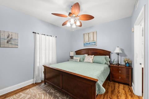 Retreat to the serene primary bedroom featuring a king bed and calming coastal décor.