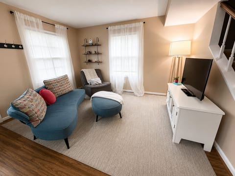 Bright, cozy living room with TV, reading chair, and natural light