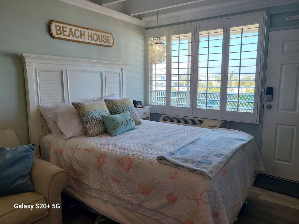 Bright sleeping area with a queen bed and a comfy sleeper sofa for flexible space.