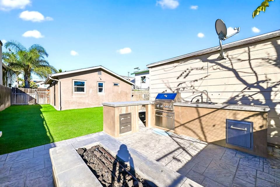 Backyard oasis: built-in grill, fire pit, and turf lawn for easy entertaining