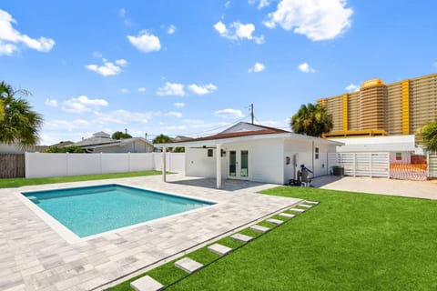 Private backyard oasis with a sparkling pool, covered patio, and plenty of space to relax just a short walk from the beach.