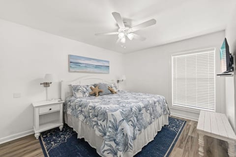 Retreat to the spacious primary bedroom featuring a king-size bed and a peaceful coastal-inspired design for restful nights.