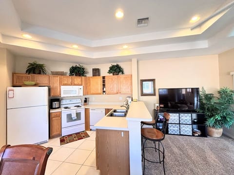Open kitchen and living area featuring full-size appliances, breakfast bar seating, and a bright, spacious layout.