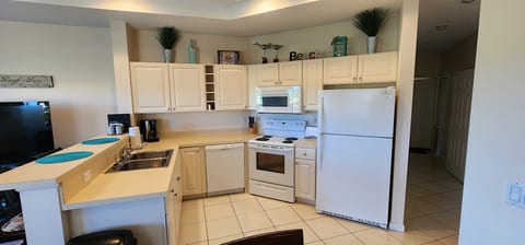 Fully equipped kitchen with full-size appliances, breakfast bar seating, and a clean, functional layout.