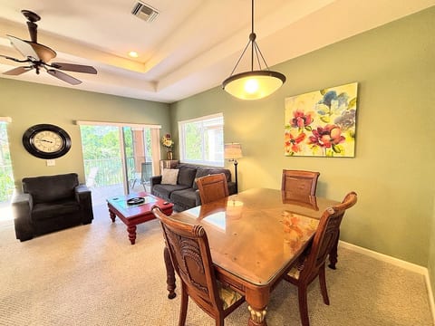Spacious dining and living area with comfortable seating, large windows, and a warm, inviting layout.