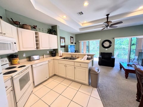 Bright open kitchen and living space with high ceilings, full-size appliances, and easy access to the main living area.