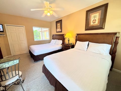 Comfortable bedroom with two beds, bedside lighting, dresser storage, and a bright, relaxing layout.