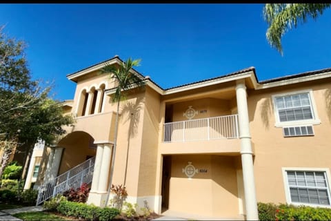 Exterior view of the building with tropical landscaping, covered entryways, and a bright Florida-style design.