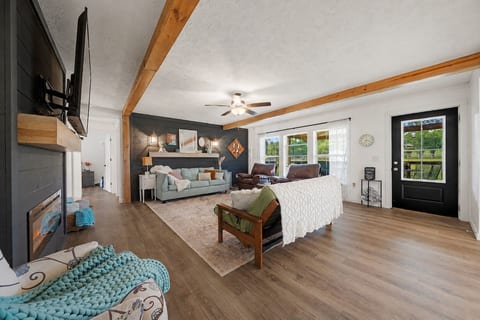 Bright, spacious living room with fireplace, TV, and scenic natural light