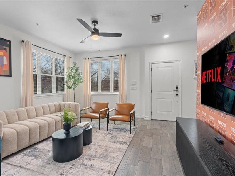 Bright modern living room with large windows and wall-mounted TV