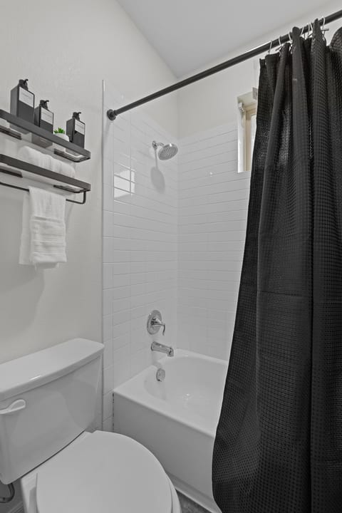 Modern bathroom with subway tile tub-shower and stylish storage