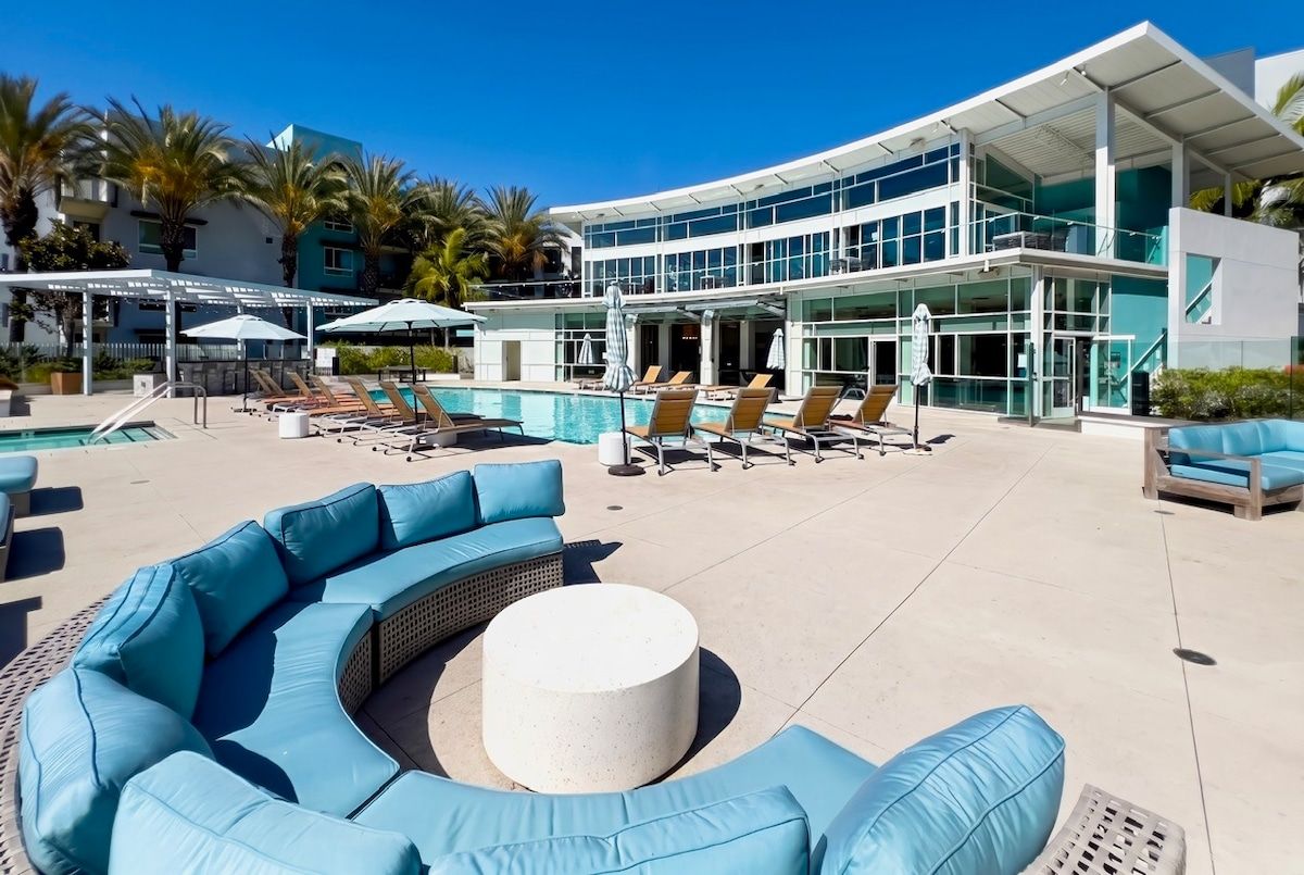 Resort-style pool deck with luxe loungers, palm views, and modern design