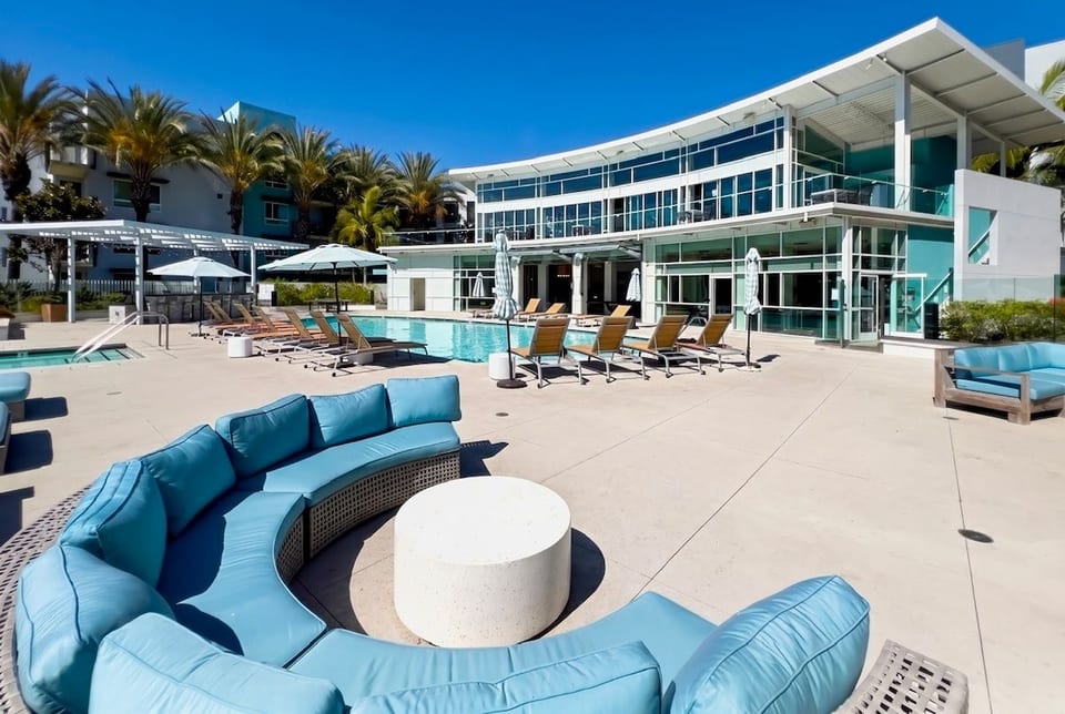 Resort-style pool deck with luxe loungers, palm views, and modern design