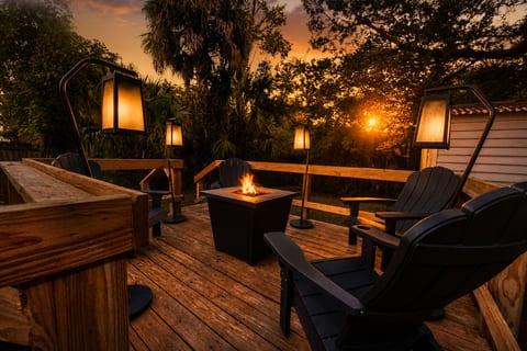 Sunset deck with fire pit, lantern lighting, and cozy Adirondack seating