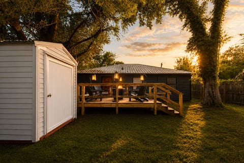 Cozy backyard deck with sunset views, outdoor seating, and shady trees