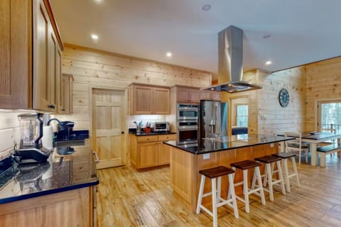 Spacious gourmet kitchen with a large island, stainless steel appliances, bar seating, and an open-concept layout perfect for gathering and entertaining.