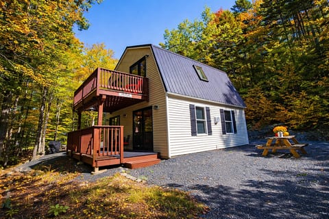 A-frame cabin with upper and lower decks, surrounded by trees and a private wooded setting.