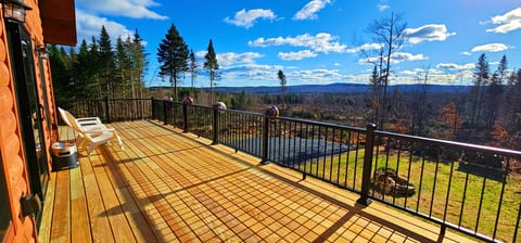 Spacious deck with outdoor seating and panoramic views of the surrounding forest and mountains.