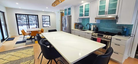 Modern kitchen with a spacious island, appliances, and open dining area, perfect for gathering, cooking, and entertaining.