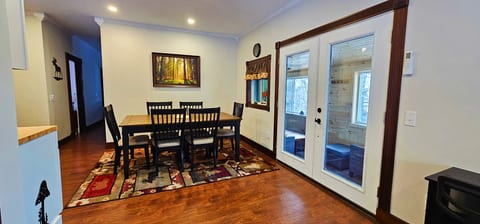 Dining area with seating for six and direct access to the covered porch, creating the perfect space for meals, games, and gathering together.