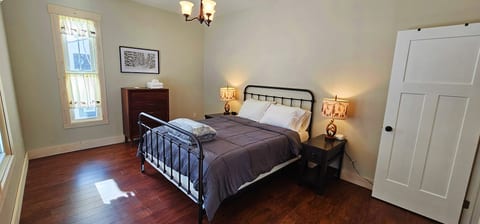 Cozy queen bedroom featuring a comfortable bed, bedside lighting, rustic cabin accents, and a peaceful space to unwind after a day of adventure.