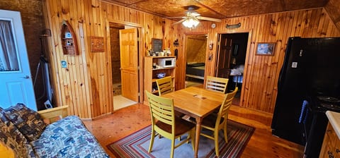 Cozy rustic cabin dining area with a full kitchen, comfortable seating, and easy access to the bedroom and bathroom for a relaxing stay.