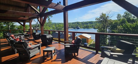 Spacious covered deck with comfortable seating, lake views, and plenty of room to relax, dine, and enjoy the outdoors in any season.