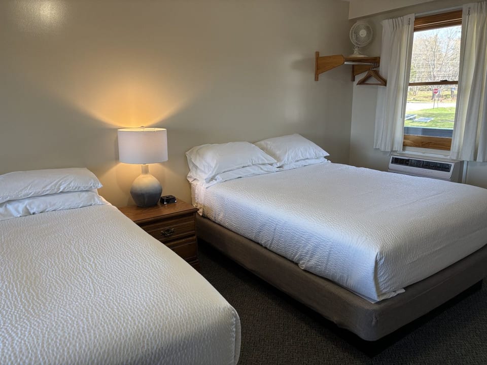 Two queen beds with soft linens, natural light, and a cozy setup for a comfortable stay.