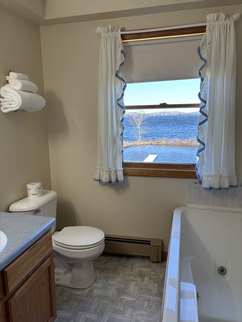Bathroom with a jetted soaking tub, fresh towels, and beautiful lake views for a relaxing retreat.